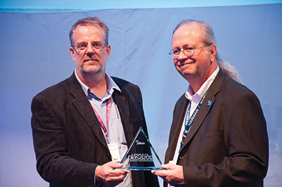 Mark Gander (right) of JBL Professional accepts a New Product Innovations award for JBL’s VTX V25 line array from PLASA chair Ed Pagett of Panalux.