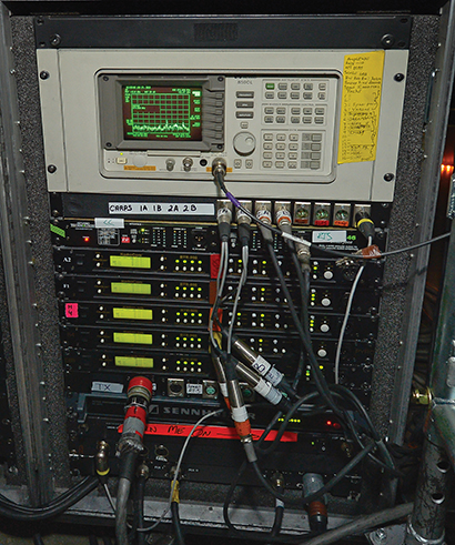 Under the stage, there's an RF rack with Hewlett Packard 8590L and Telex RadioCom BTR-800 transmitters. Photo by Steve Jennings