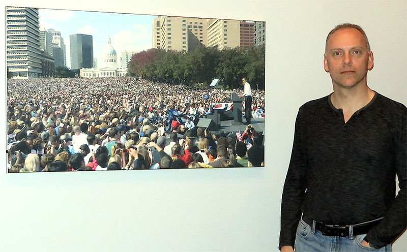 Chip Self in the conference room at Logic Systems, near a photo of the 2008 Obama rally in St Louis, attended by close to 100,000. Photo by Kevin M. Mitchell