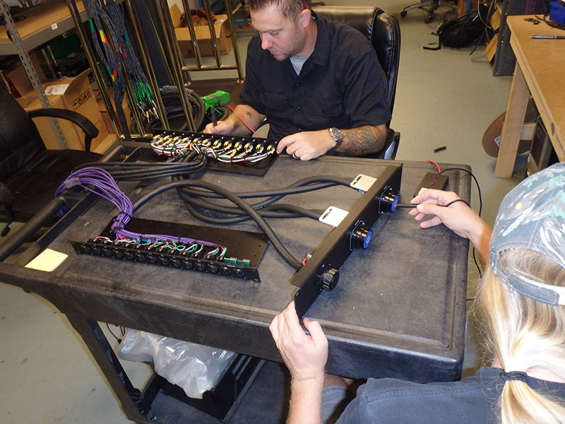 Quality control is an essential part of the EMG operation. Here, a custom stagebox harness is hand-checked prior to delivery.