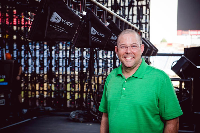 Jason Glass, principle of Clean Wireless Audio, stands on the main stage at LP Field, in front of seven RF Venue CP Beam antennas mounted to trussing.