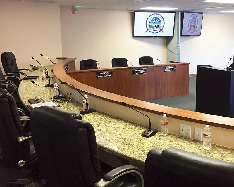 A view of the city council chambers in Wildomar, CA, featuring Audio-Technica U857QL Cardioid Condenser Quick-mount Gooseneck Microphones, each attached to an A-T ATND8677 Microphone Desk Stand with Dante network output.