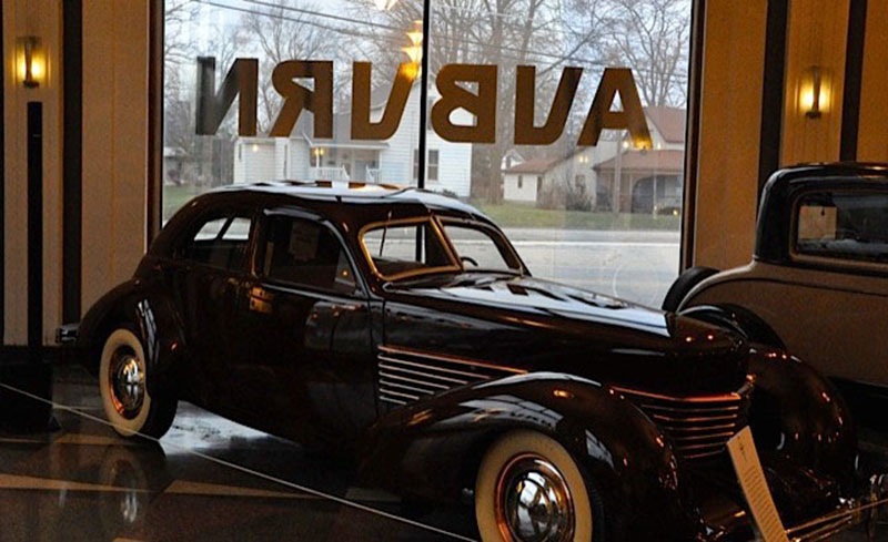 An exhibit at the Auburn Cord Duesenberg Automobile Museum in Auburn, Indiana, featuring one of seven Bose L1 Compact portable line array sound systems (background, left).