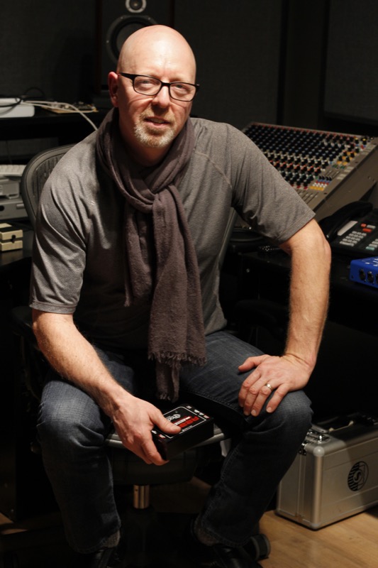 Jim-Rhodes-holding-a-Reamp-JCR-in-front-of-mixer