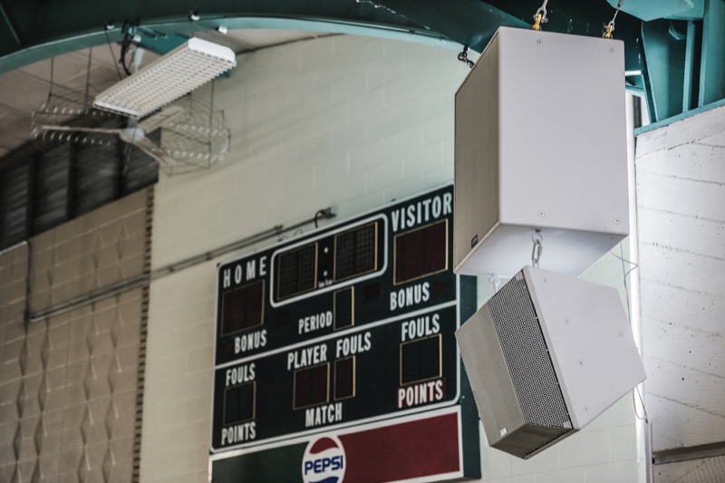 The scoreboard at St. Francis High School gymnasium, with EAW loudspeakers beside.