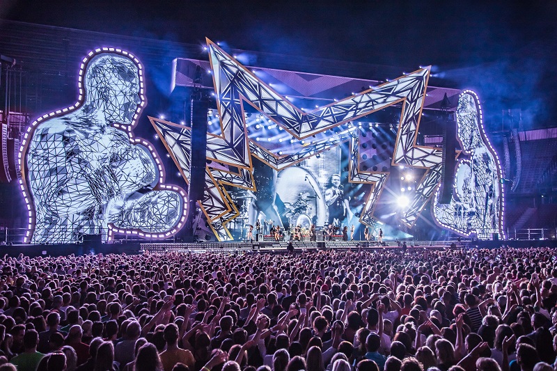 Robbie-Williams-Klagenfurt-2017_Photo-Ralph-Larmann_1.jpg and Robbie-Williams-Klagenfurt-2017_Photo-Ralph-Larmann_2.jpg: The L-Acoustics system for Robbie Williams’ Heavy Entertainment Show comprises 14 K1, two K2 and four K1-SB, with 14 K1 and between four and six K2 for side hangs, depending on the venue. Sub hangs of K1-SB are flown behind the side hangs to help with low end coverage out to the side of the stadiums and rear hangs of up to 12 K2 help with the furthest upstage seats. © Ralph Larmann