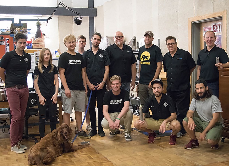 (left to right): Kelvin Collins (M60 FET technician), Shelby Pelumbo (Diamond Series technician), Eric Freudenstein (CU-29 technician), Thom Hickey (Diamond Series technician), Alex Nocenzo (Diamond Series technician), David Seal (TransAudio), Alan Venitosh (TELEFUNKEN Director of Operations), Brad Lunde (TransAudio), Zach Winterfeld (TransAudio). Seated (left to right): Ruby (frequency response testing dog), Bobby Dyckman (Dynamic Series technician), Ian Cluggish (Diamond Series technician), James Duffy (Diamond Series technician)