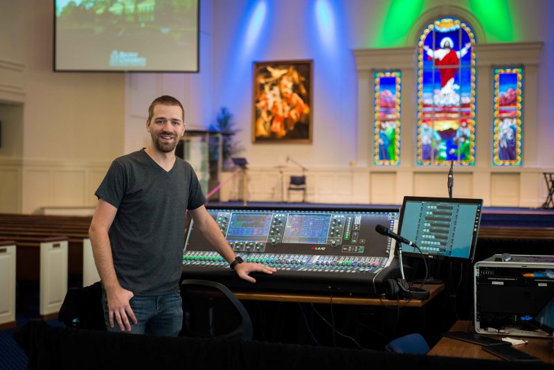 Regent University Chief Audio Engineer Justin Fugett stands at the helm of an Allen & Heath dLive S7000 control surface