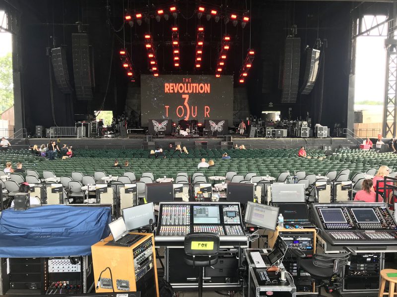 A view of Revolution 3 Tour’s stage and L-Acoustics K1/K2 system from behind the three bands’ mixing consoles at FOH